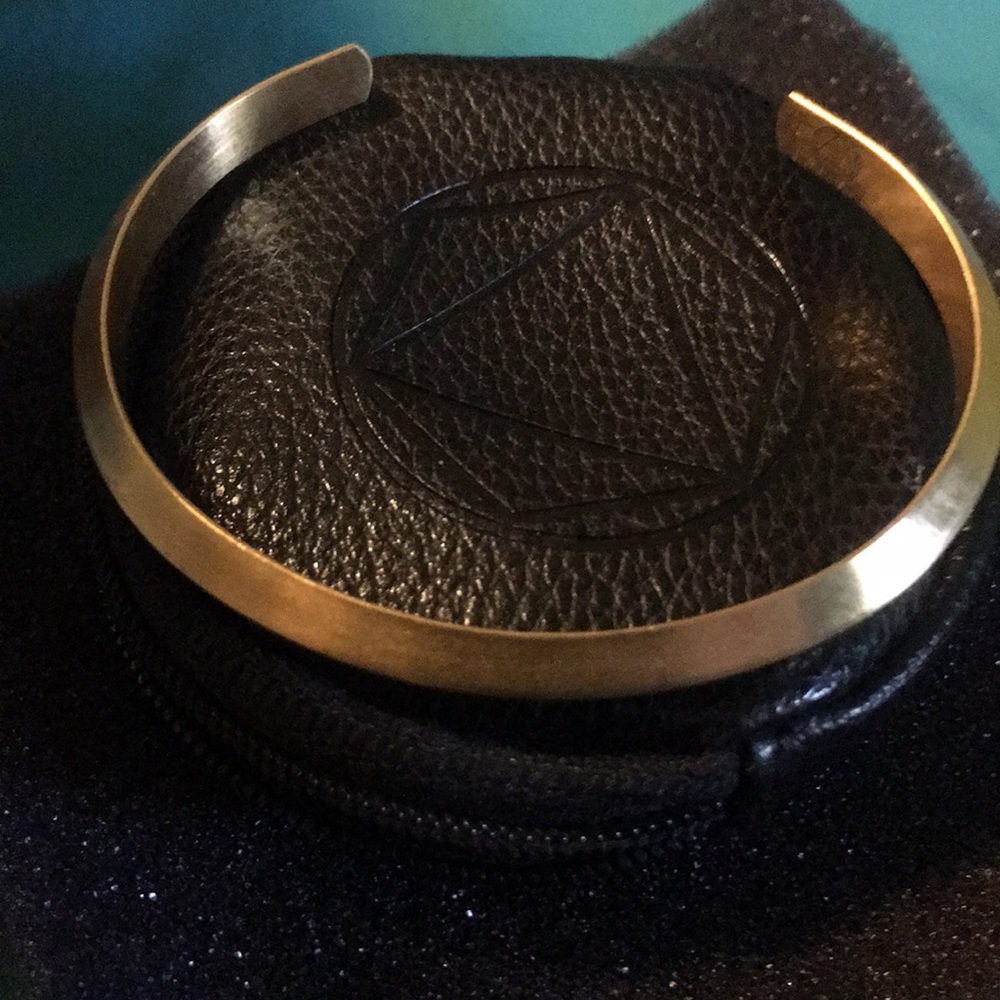 Gold cuff bracelet with black storage case